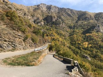 Road amidst plants and mountains against sky