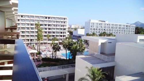 Buildings by swimming pool against blue sky