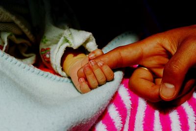 Cropped image of baby holding finger