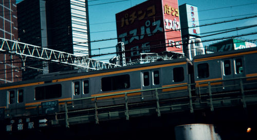 Train on railroad tracks by buildings in city