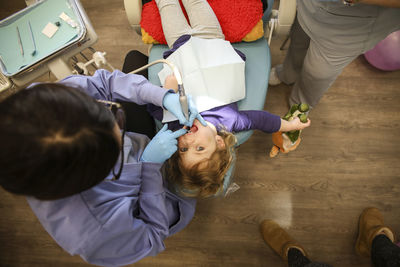 Overhead view of dentist examining girl in clinic
