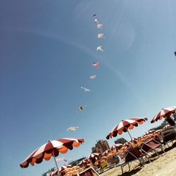 Low angle view of flags against clear blue sky