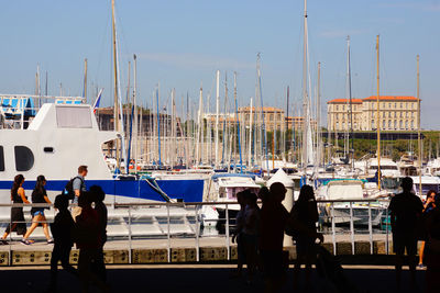 People at harbor against sky