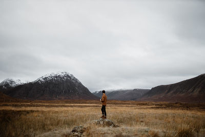 Man standing on mountain against sky