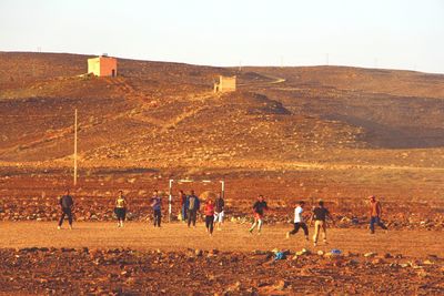 People on beach against clear sky