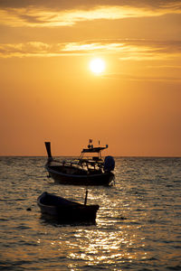 Boat in sea against sky during sunset