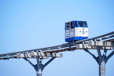 Low angle view of coast skyrail against clear blue sky