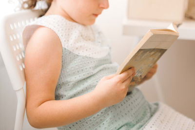 Midsection of woman reading book