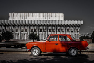 Vintage car on street in city against sky