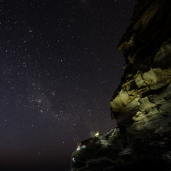 Low angle view of rocks against sky at night