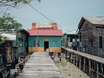 Footpath amidst buildings against clear sky