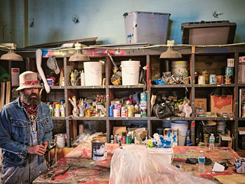 An eclectically dressed artist in his art making space.