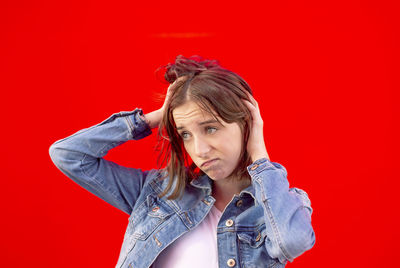 Portrait of beautiful woman against red background