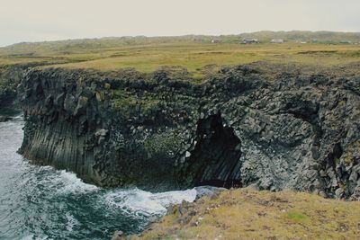Scenic view of rocks on sea against sky