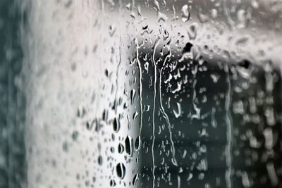 Close-up of wet glass window during rainy season