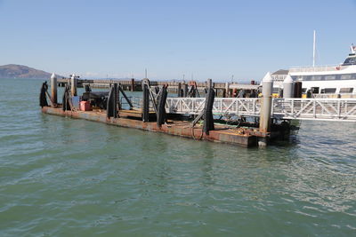 View of pier in sea against clear sky