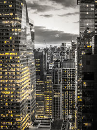 Illuminated buildings in city against sky