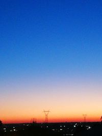 Scenic view of silhouette city against clear sky during sunset