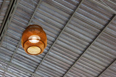 Low angle view of illuminated lamp hanging on ceiling