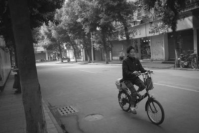 People riding bicycle on street in city