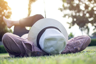 Man lying on field against sky