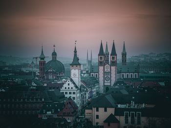 Buildings in city against sky during sunset