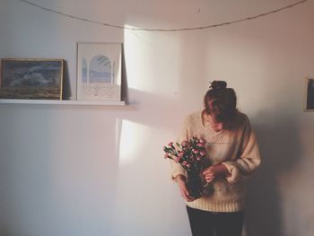 Woman standing against wall at home