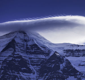 Close up of cloud above snow covered mountain summit