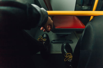 Low section of man wearing shoes in bus