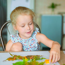 Close-up of cute girl sitting on table
