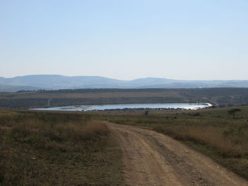 Road by landscape against clear sky