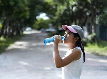 Asian young woman drinking water after jogging,healty and sport concept.