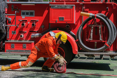 Fire fighter working on road by firetruck