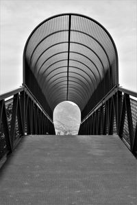 Empty footbridge against sky