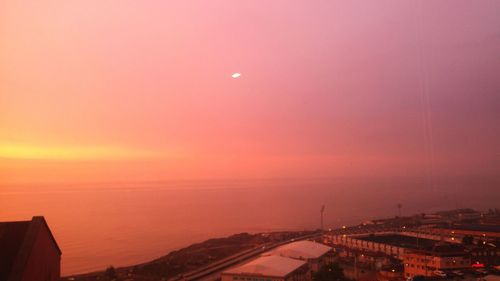 Aerial view of city against orange sky