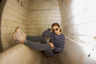 Portrait of man sitting against wall