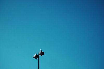 Low angle view of street light against clear blue sky