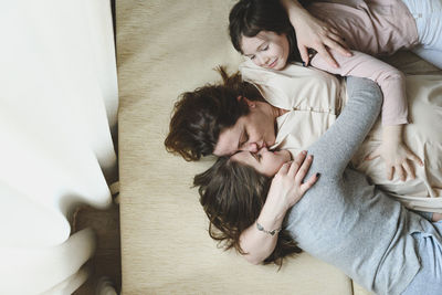 Mother lying with daughters at home