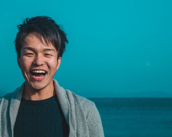 Close-up of smiling man against blue background