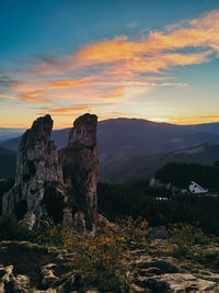 Rock formations on landscape against sky during sunset