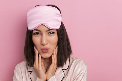 Portrait of young woman against yellow background