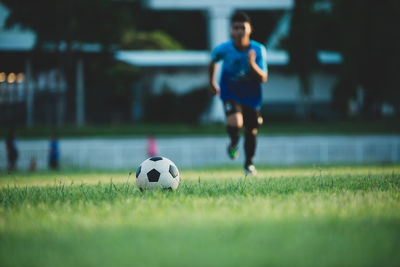 Man playing soccer ball on grass