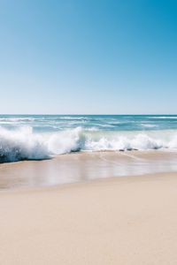 Scenic view of beach against clear blue sky