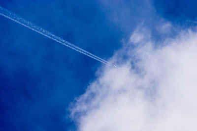 Low angle view of vapor trail against blue sky