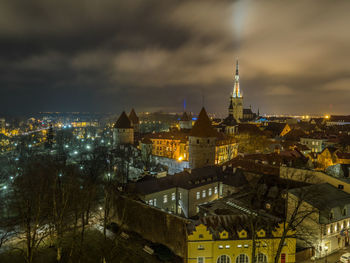 Illuminated cityscape against sky at night