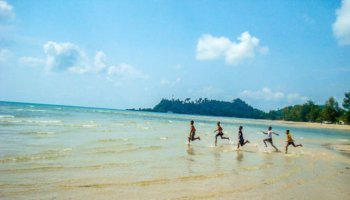 People on beach against sky