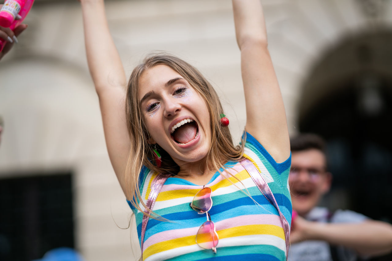happiness, women, focus on foreground, lifestyles, mouth open, arms raised, emotion, front view, cheerful, smiling, real people, human arm, leisure activity, mouth, one person, enjoyment, fun, portrait, positive emotion, excitement, hairstyle