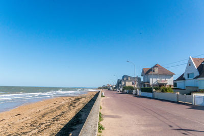 Scenic view of beach against clear blue sky