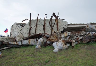 Damaged building on field against sky