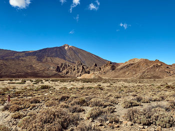 Scenic view of desert against blue sky